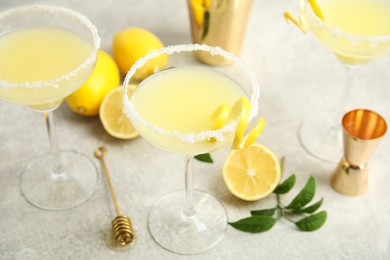 Photo of Delicious bee's knees cocktails and ingredients on light grey table