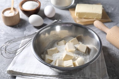 Photo of Making shortcrust pastry. Different ingredients for dough, whisk and rolling pin on grey table