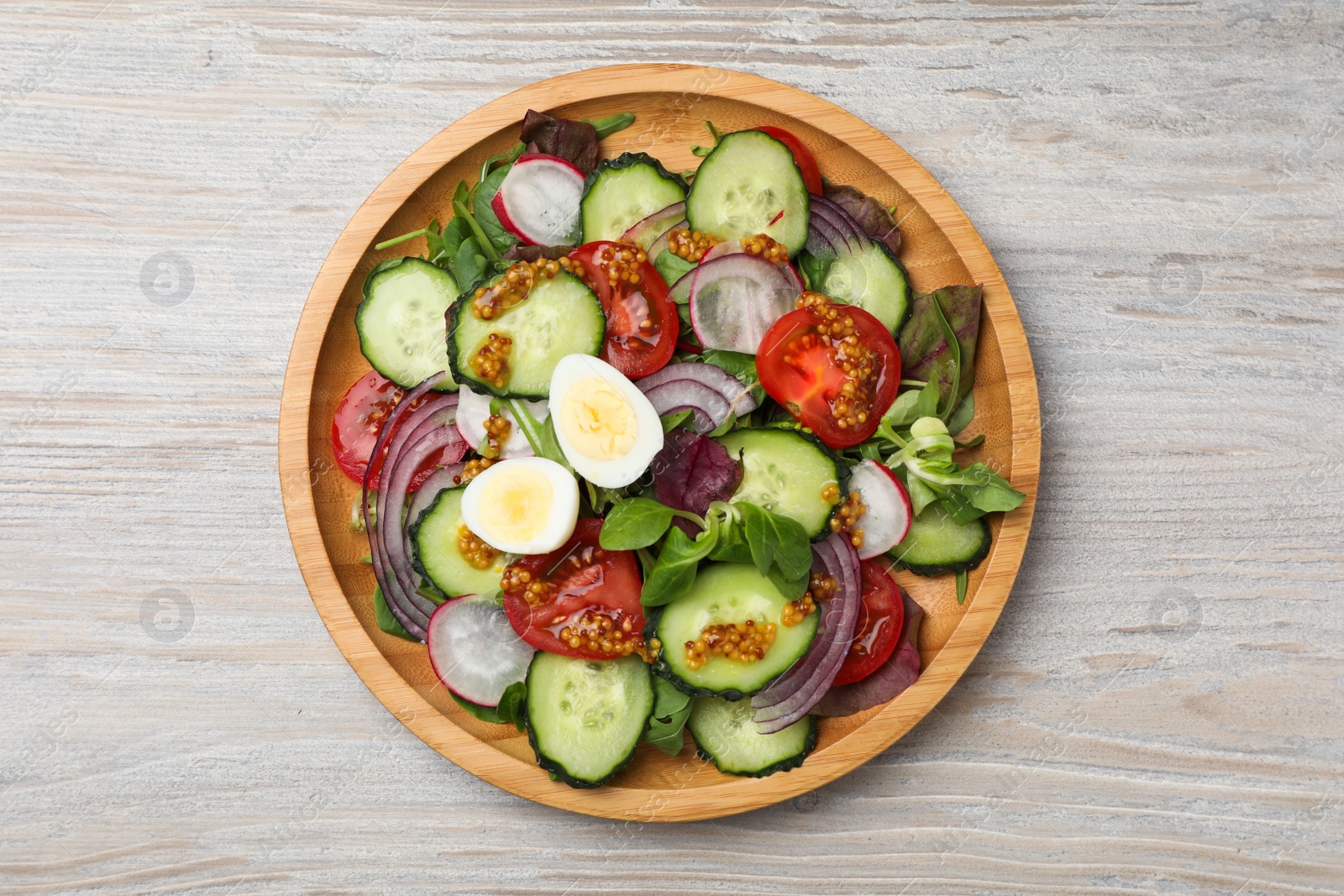 Photo of Tasty salad with vegetables and quail eggs on wooden table, top view