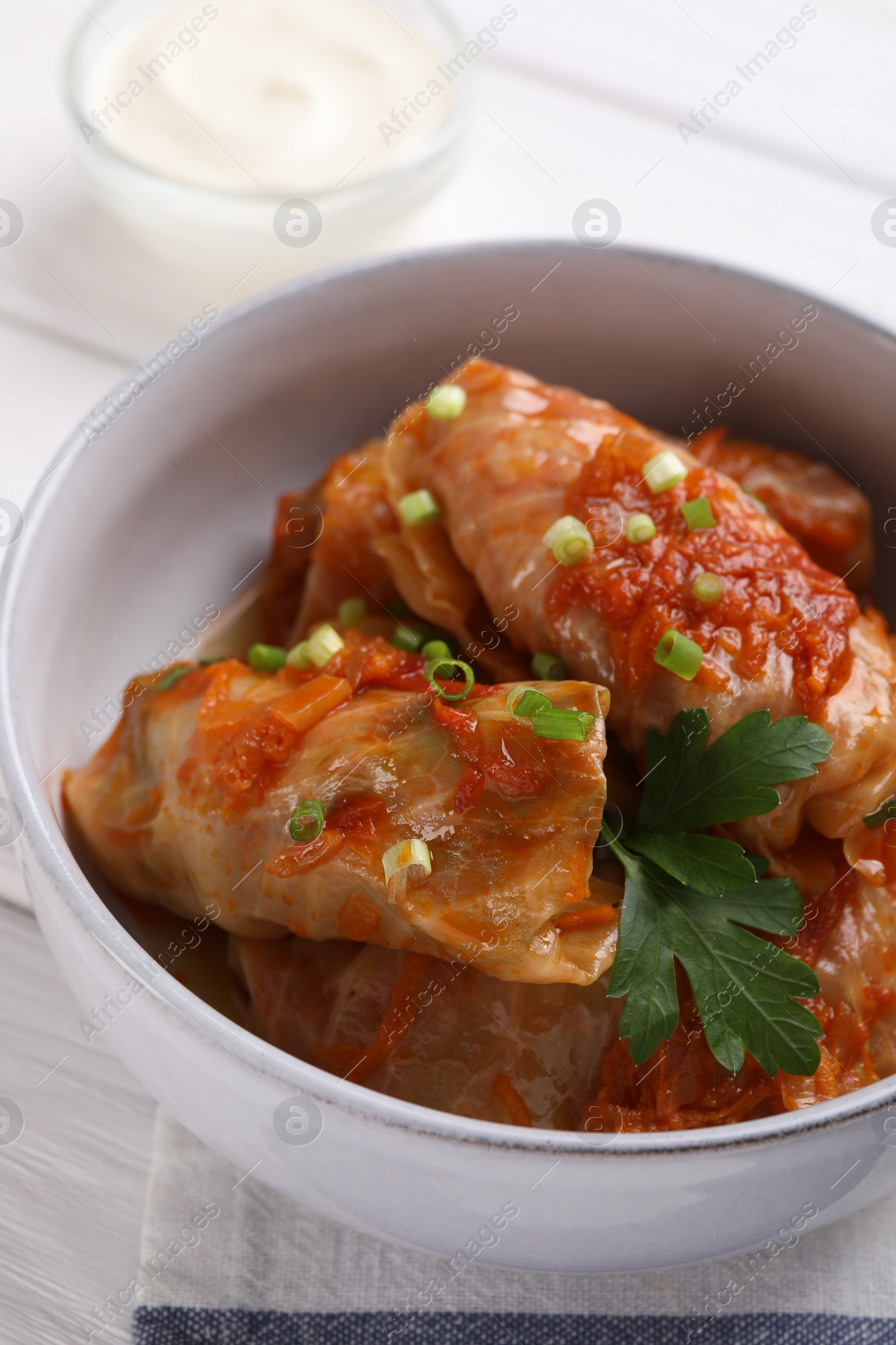 Photo of Delicious stuffed cabbage rolls cooked with homemade tomato sauce on table, closeup