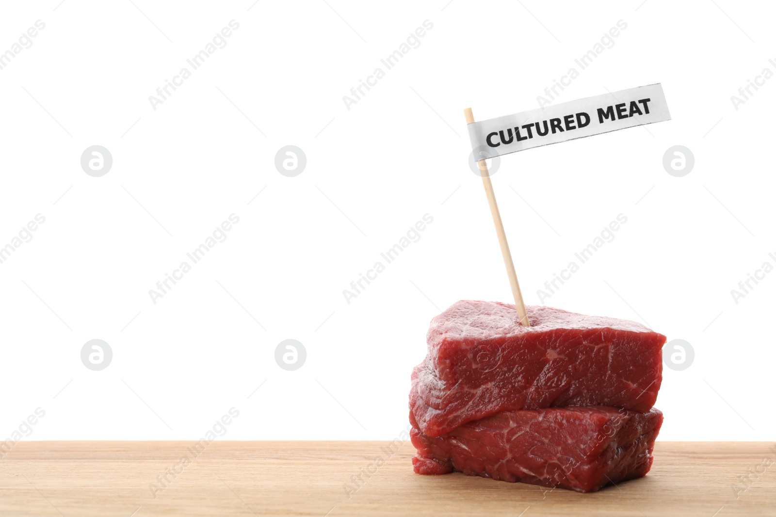 Photo of Pieces of raw cultured meat with toothpick label on wooden table against white background