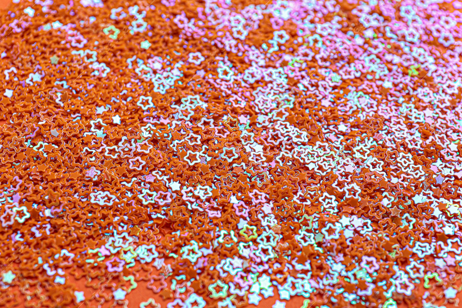 Photo of Shiny bright star shaped glitter as background, closeup view