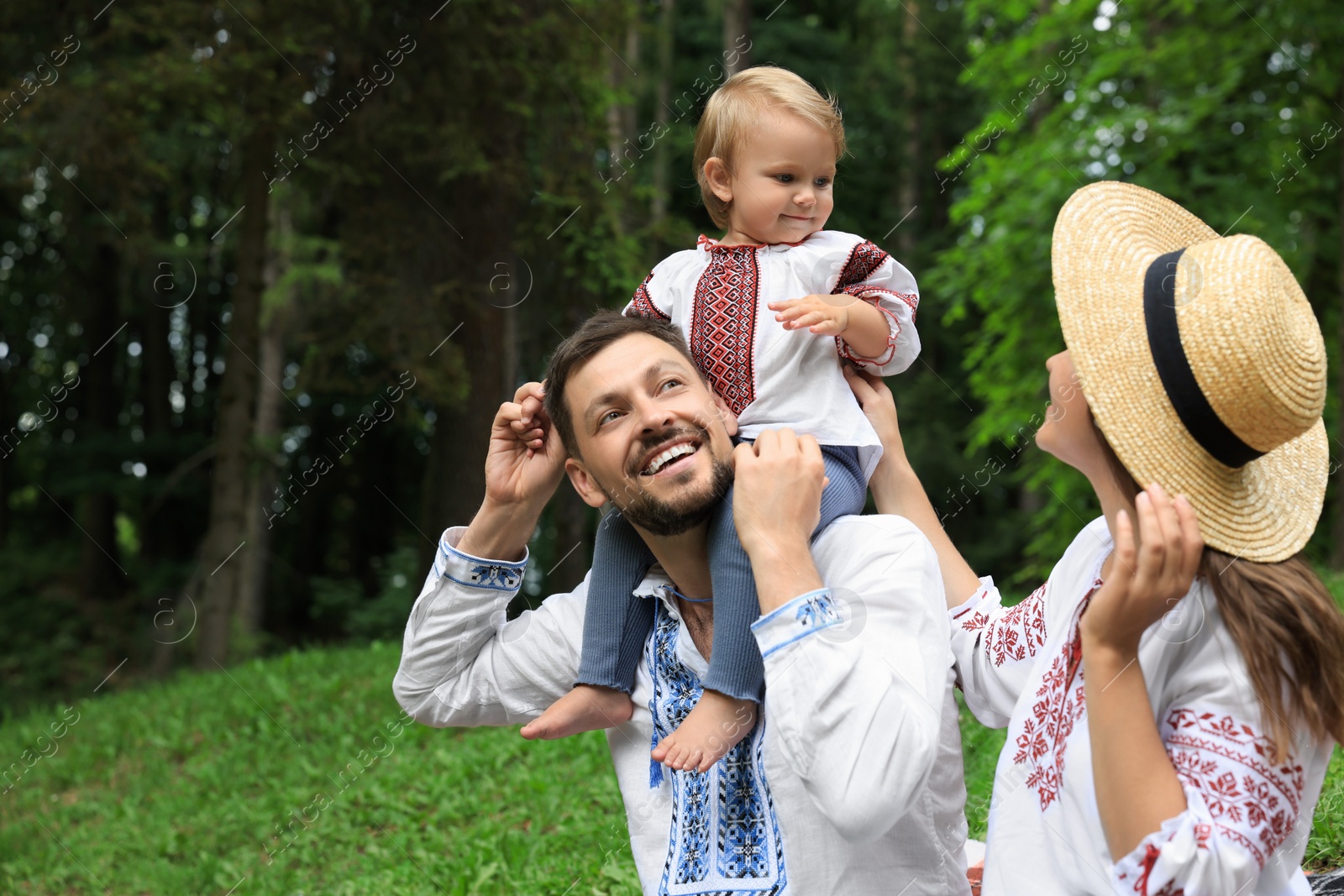 Photo of Happy family in Ukrainian national clothes outdoors