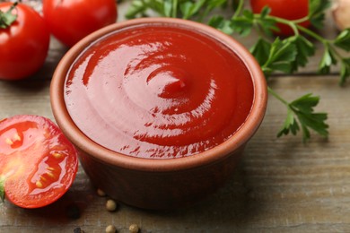 Photo of Tasty ketchup, fresh tomatoes, parsley and spices on wooden table, closeup