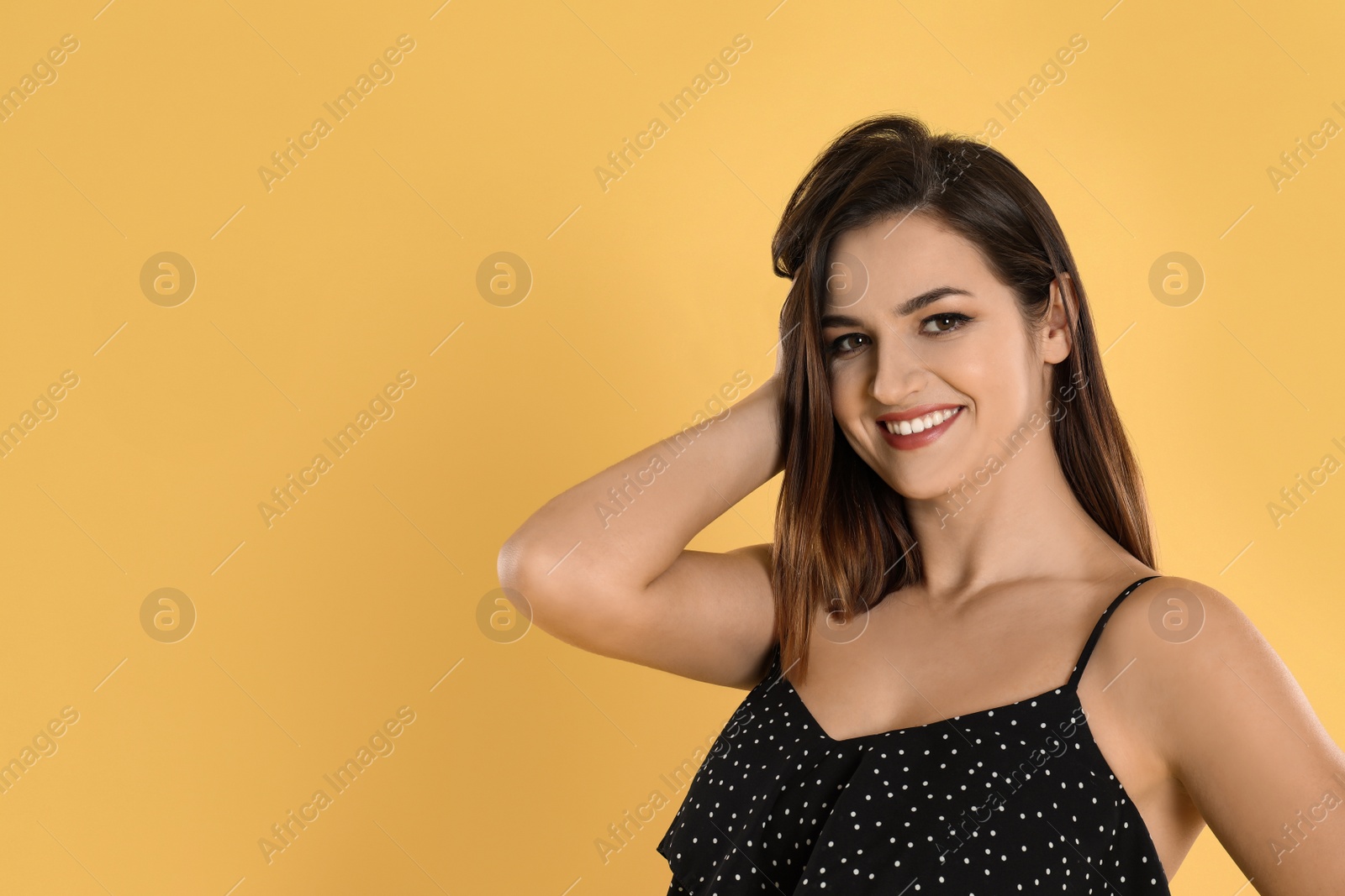 Photo of Happy beautiful young woman on yellow background. Space for text