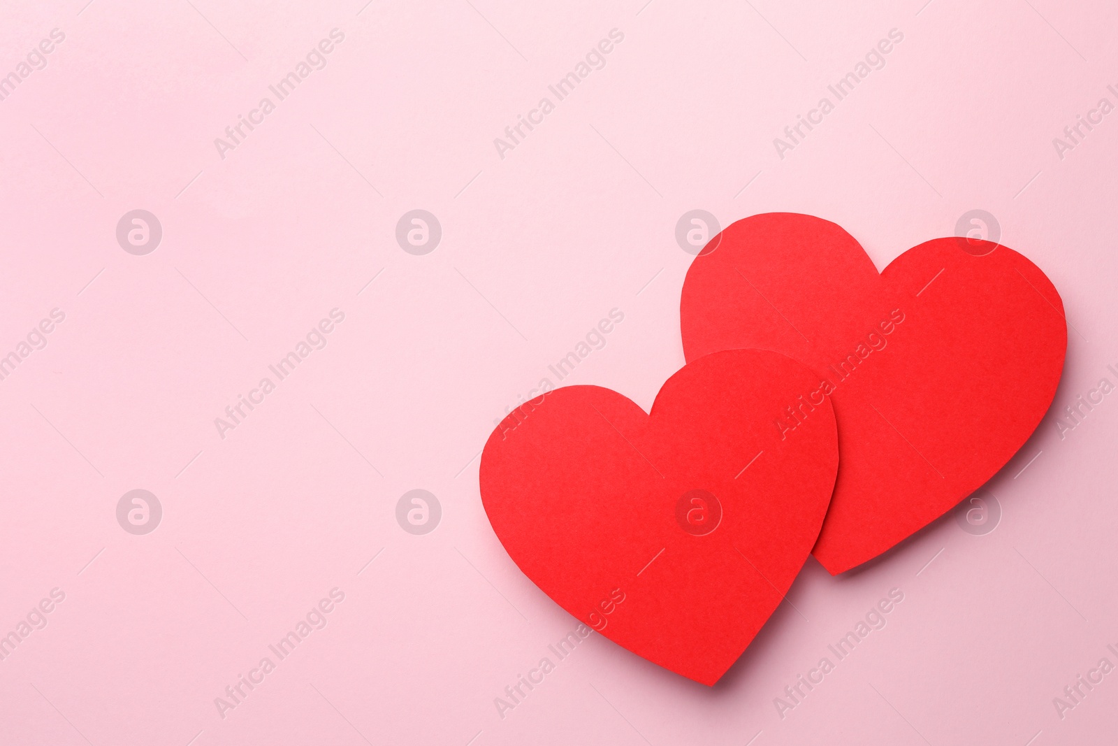 Photo of Paper hearts on pink background, top view. Space for text