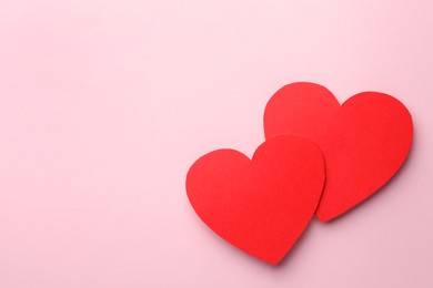 Paper hearts on pink background, top view. Space for text