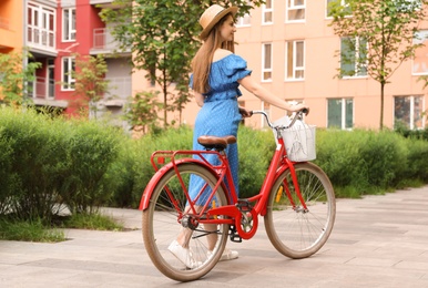 Photo of Young pretty woman with bicycle in city