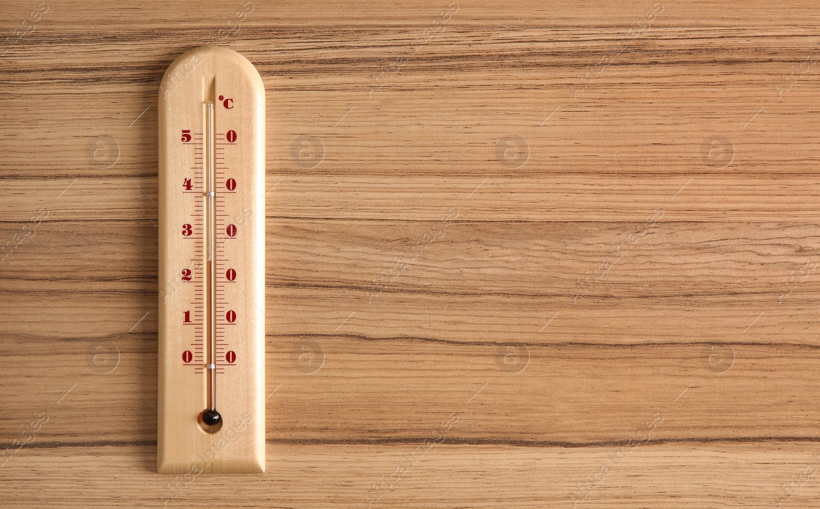 Photo of Weather thermometer on wooden table, top view. Space for text