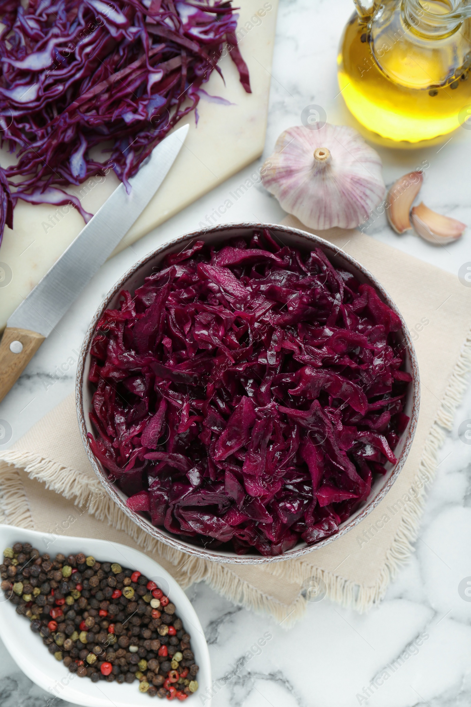 Photo of Tasty red cabbage sauerkraut and ingredients on white marble table, flat lay