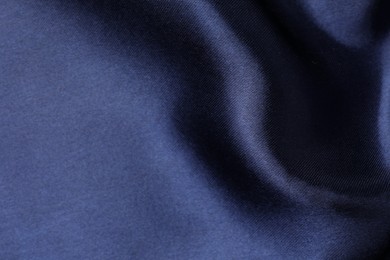 Photo of Crumpled dark blue silk fabric as background, closeup