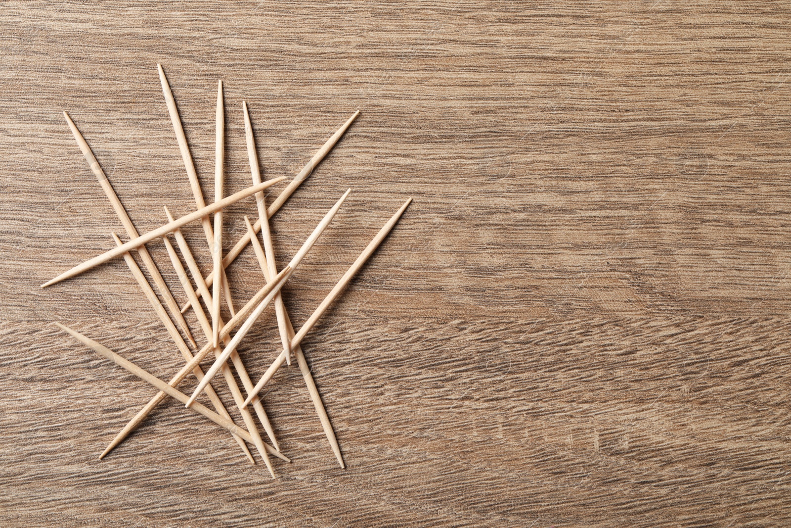 Photo of Disposable toothpicks on wooden background, flat lay. Space for text