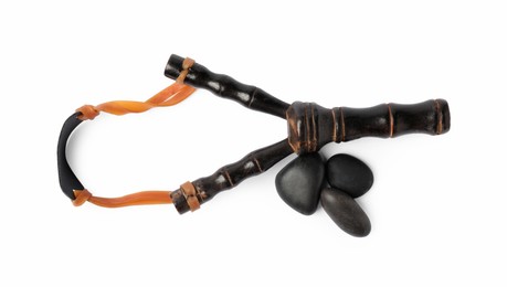 Photo of Black wooden slingshot with stones on white background, top view