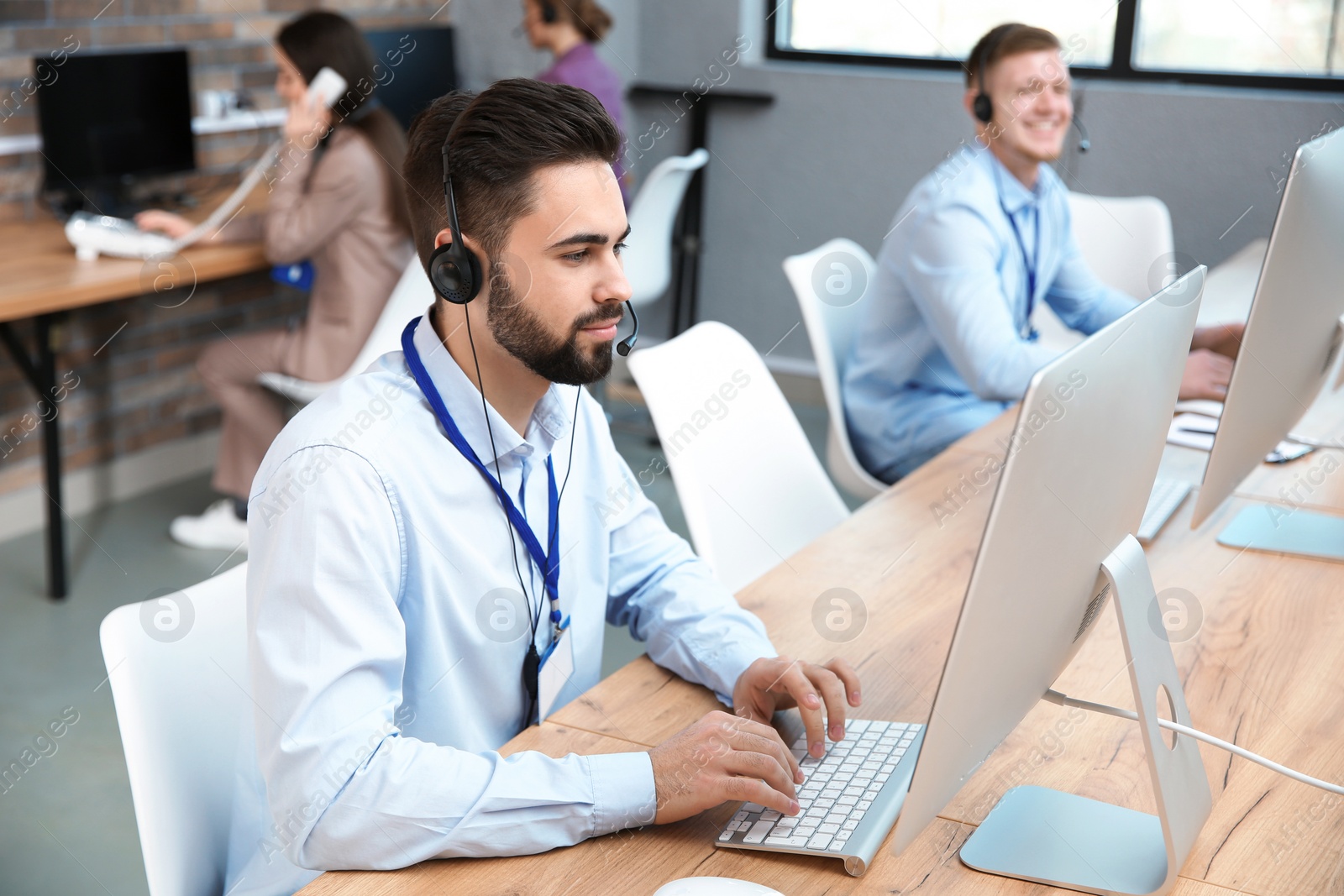 Photo of Technical support operator working with colleagues in office