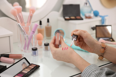 Photo of Woman applying makeup at dressing table, closeup