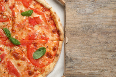 Delicious pizza Margherita on wooden table, top view. Space for text