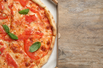 Photo of Delicious pizza Margherita on wooden table, top view. Space for text