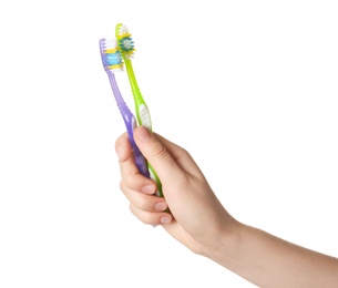 Woman holding manual toothbrushes against white background