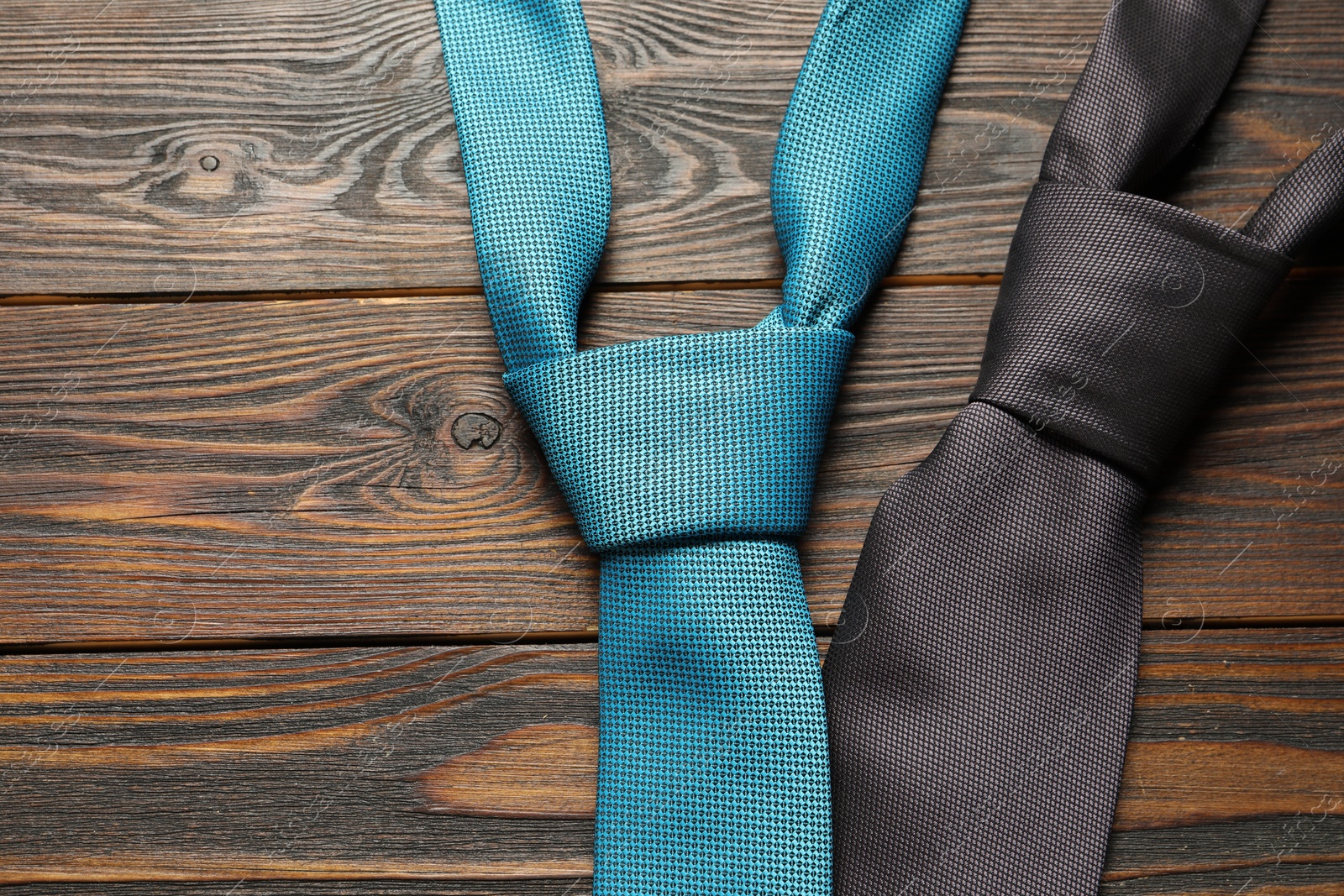 Photo of Two neckties on wooden table, top view. Space for text