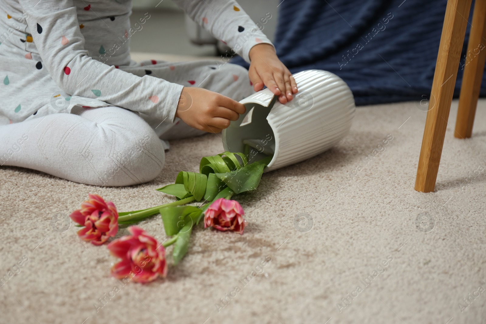 Photo of Child and broken ceramic vase on floor at home, closeup