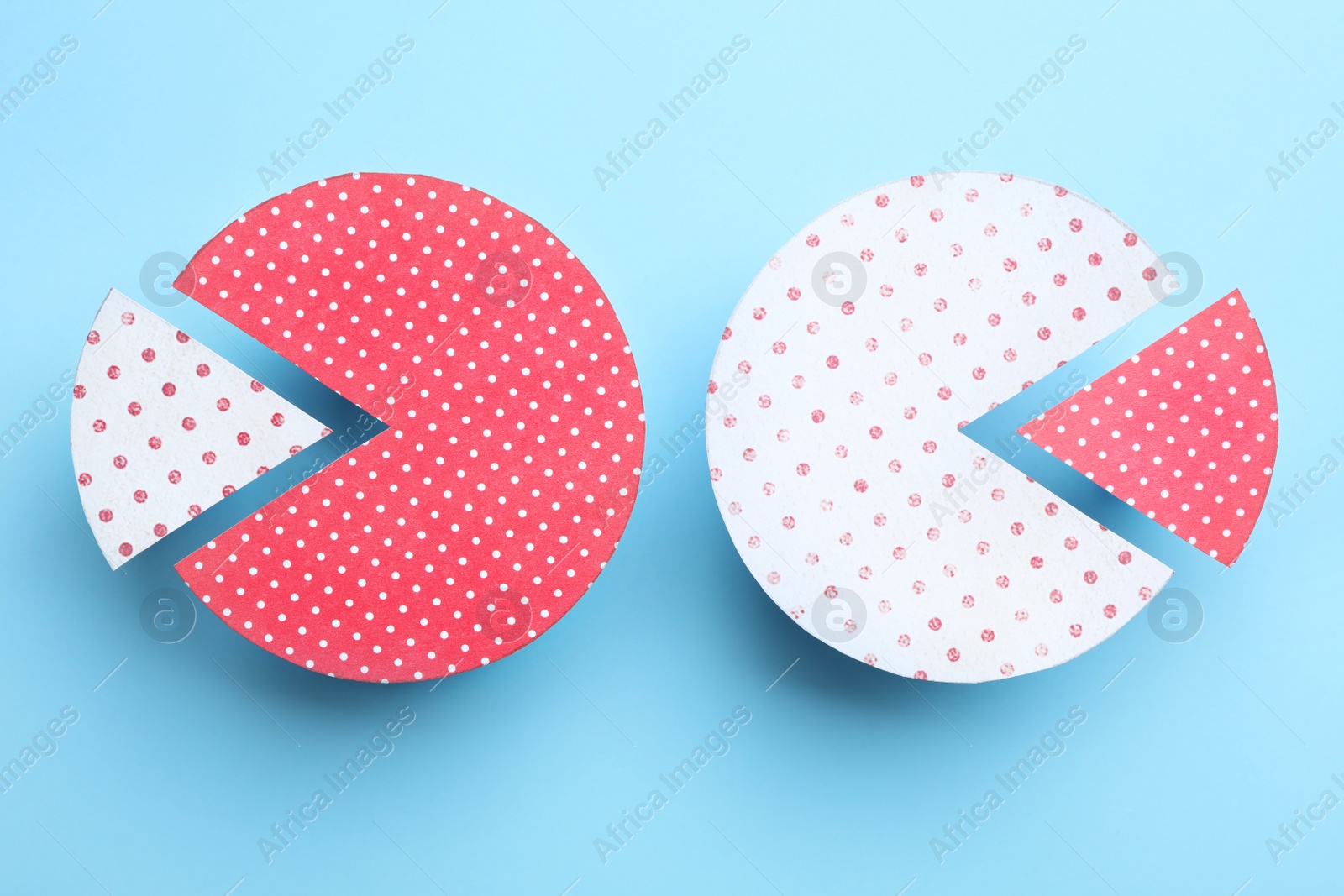 Photo of Paper circles with exchanged segments on light blue background, flat lay. Pareto principle concept