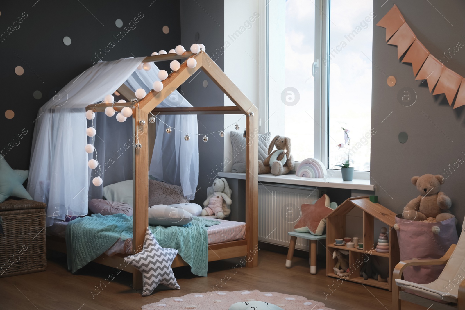 Photo of Stylish child room interior with house bed and different toys