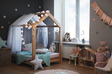 Stylish child room interior with house bed and different toys