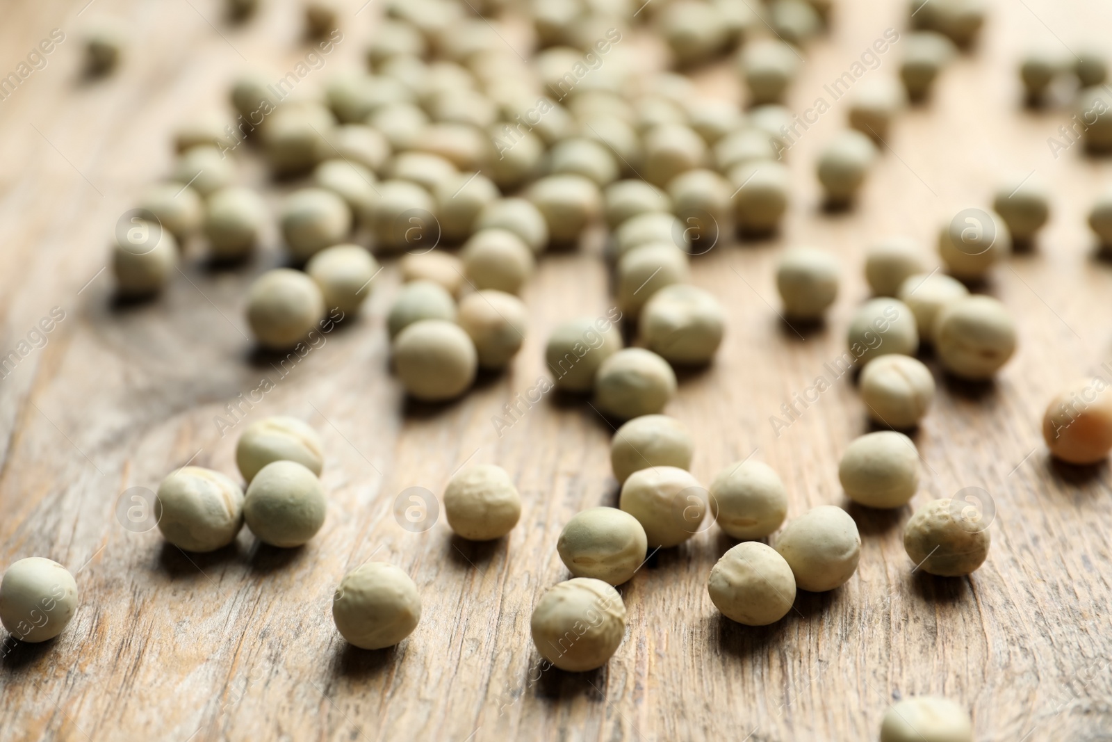 Photo of Raw dry peas on wooden background, closeup. Vegetable seeds