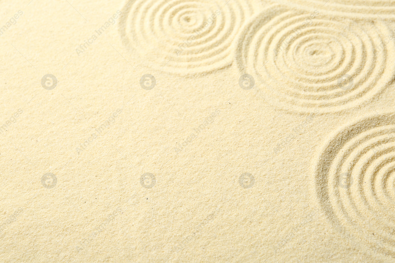 Photo of Zen rock garden. Circle patterns on beige sand