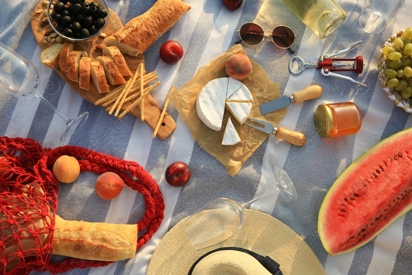 Photo of Different tasty snacks on picnic blanket, flat lay