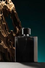 Luxury men`s perfume in bottle on grey table against color background