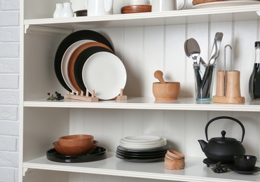 Photo of White shelving unit with set of dishware