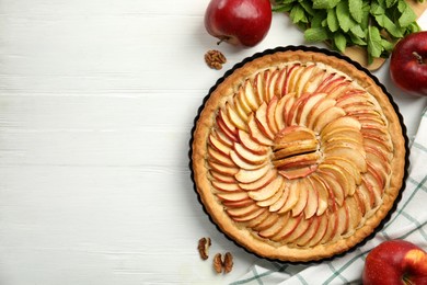 Flat lay composition with delicious homemade apple tart on white wooden table. Space for text