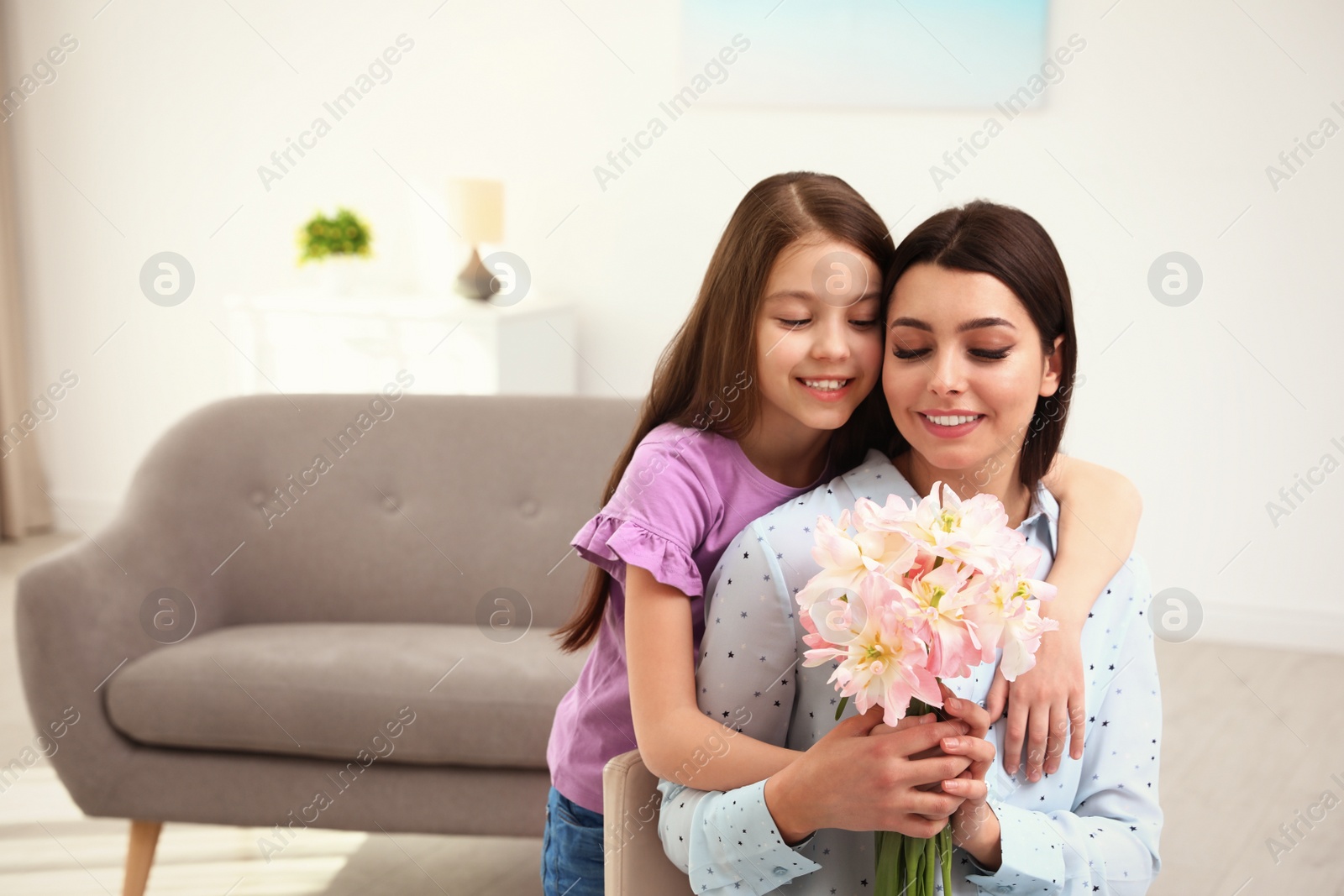 Photo of Little daughter congratulating her mom at home, space for text. Happy Mother's Day