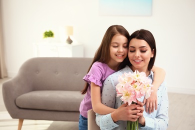 Photo of Little daughter congratulating her mom at home, space for text. Happy Mother's Day