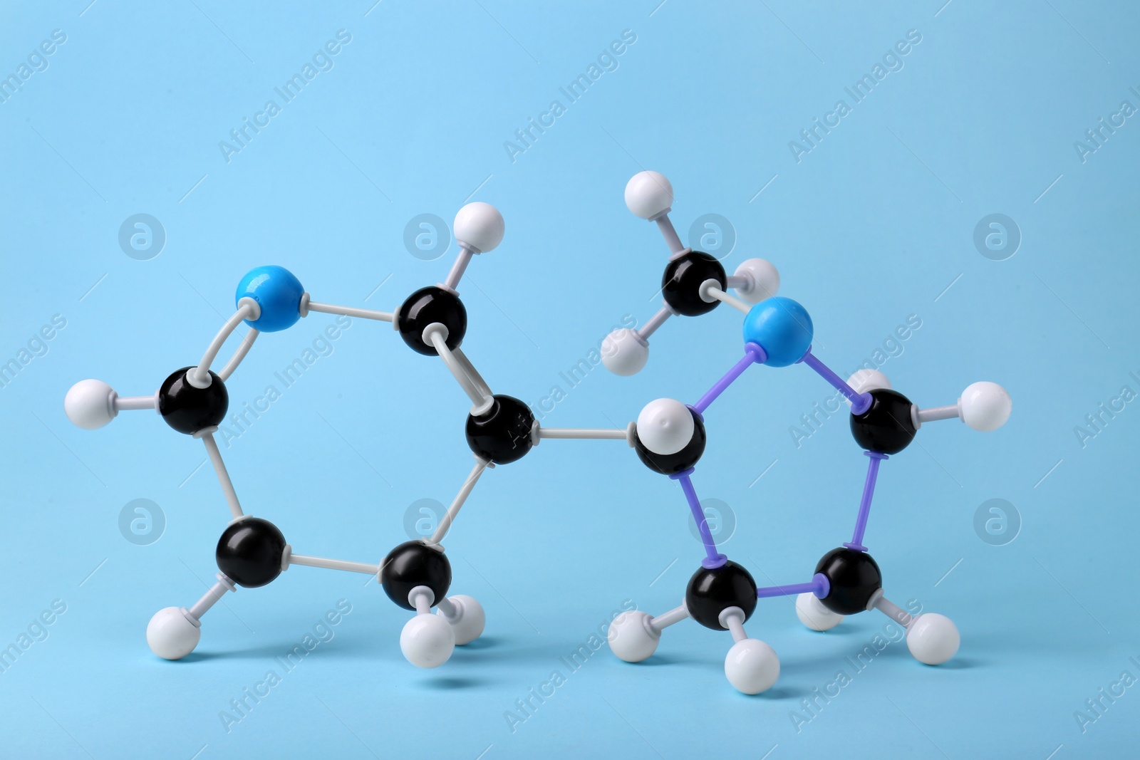 Photo of Molecule of nicotine on light blue background. Chemical model