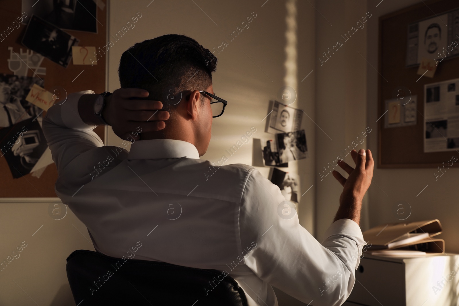 Photo of Detective looking at evidence board in office