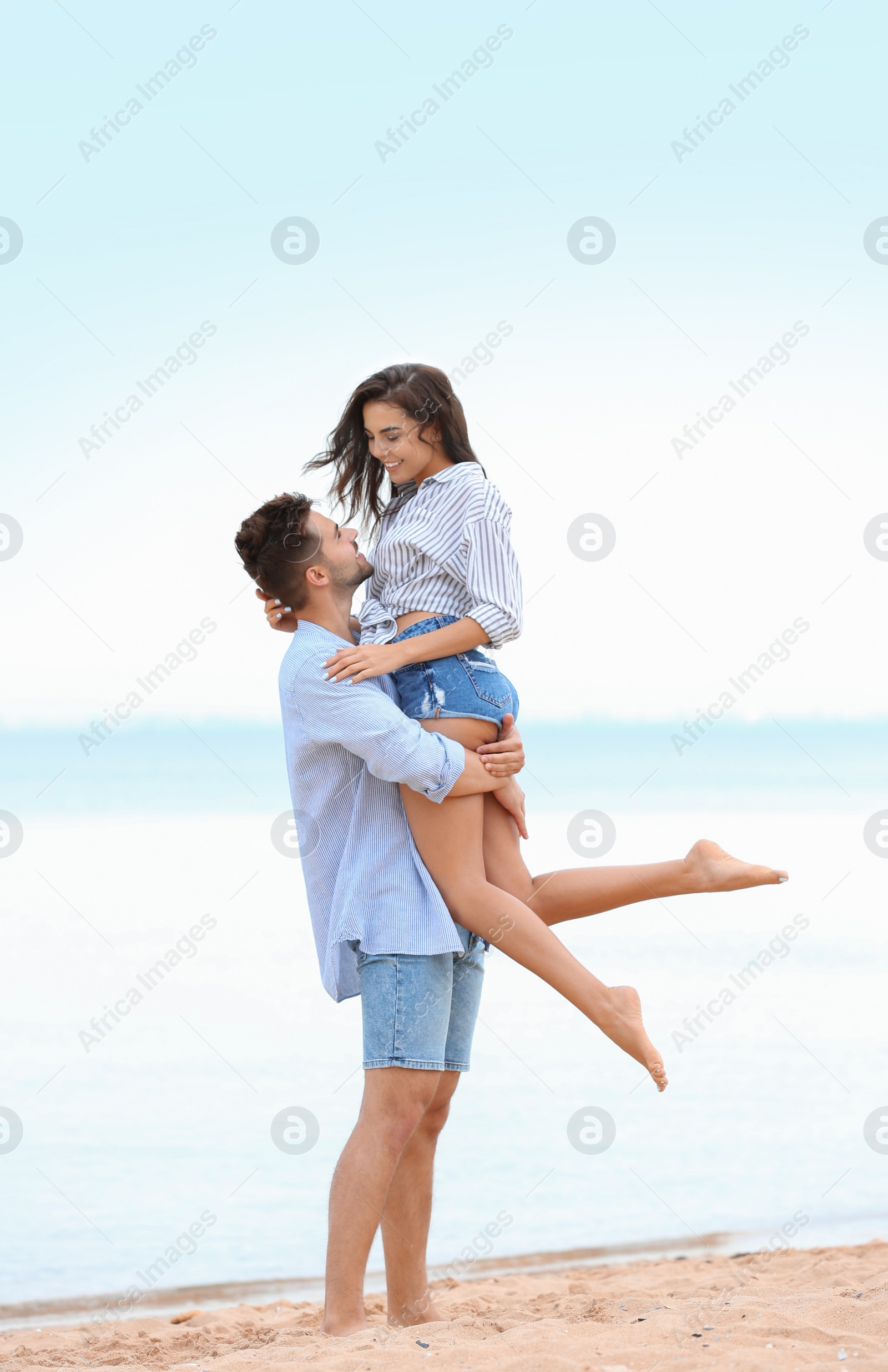 Photo of Happy young couple spending time together on beach near sea