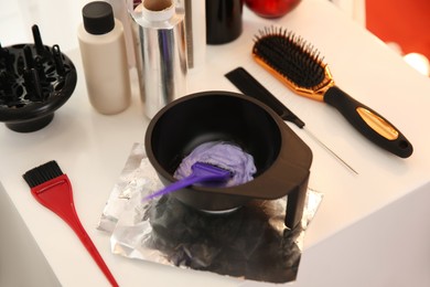 Photo of Workplace with hair dye kit on table in beauty salon