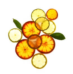 Illuminated slices of citrus fruits and leaves on white background, top view