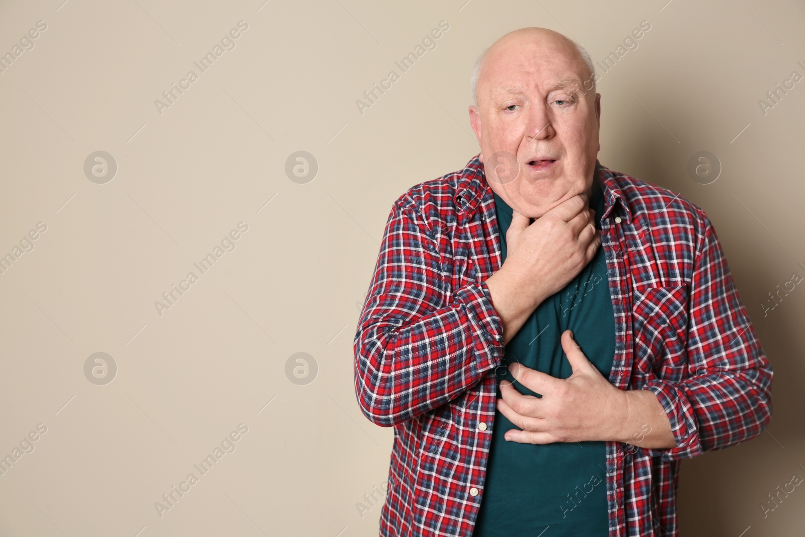 Photo of Senior man suffering from cough on color background. Space for text