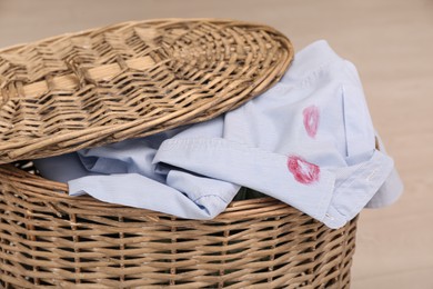 Photo of Men's shirt with lipstick kiss marks in laundry basket, closeup