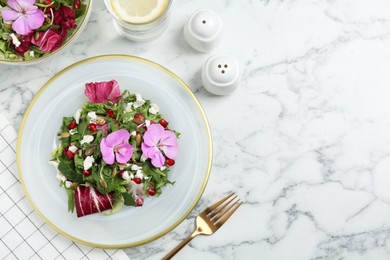 Photo of Fresh spring salad with flowers served on white marble table, flat lay. Space for text