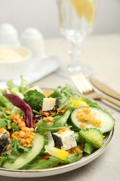 Delicious salad with lentils, vegetables and cheese served on light grey table