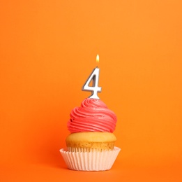 Photo of Birthday cupcake with number four candle on orange background