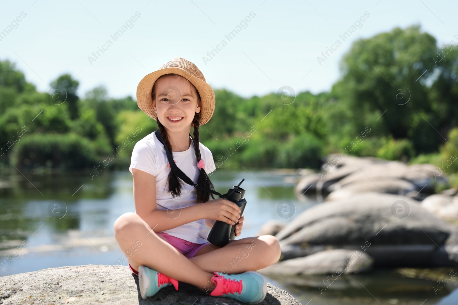 Photo of Little girl with binoculars outdoors. Summer camp