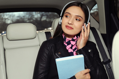 Young woman listening to audiobook in car