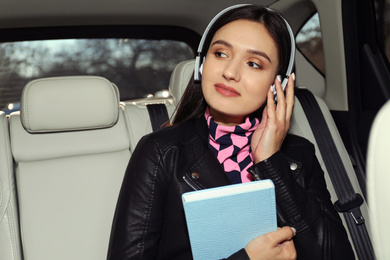 Photo of Young woman listening to audiobook in car