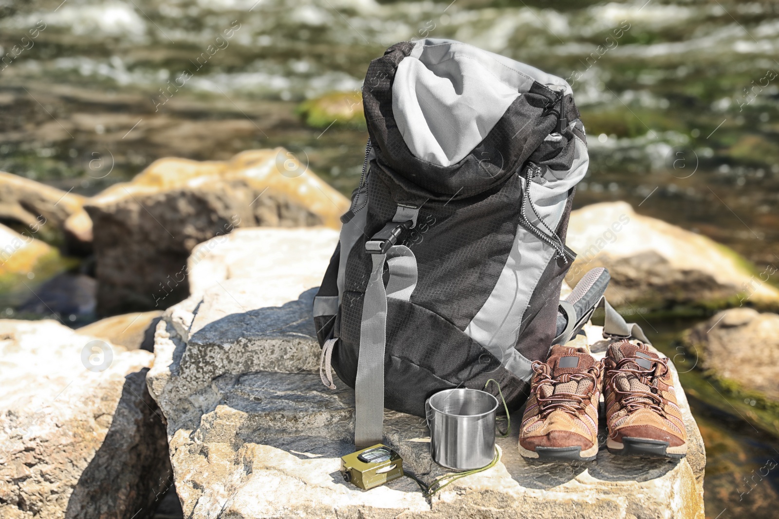 Photo of Traveling gear on rock near river. Summer camp