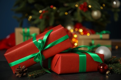 Photo of Beautiful gift boxes and Christmas decor on black table, closeup